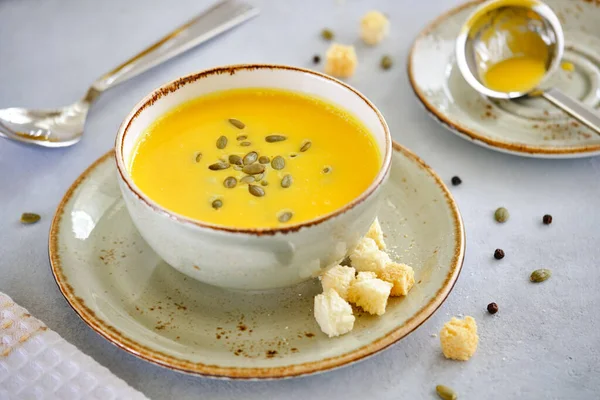 Lezzetli ve sağlıklı beslenme yemekleri. Gri arka planda balkabağı çorbası kreması. Yakın plan.