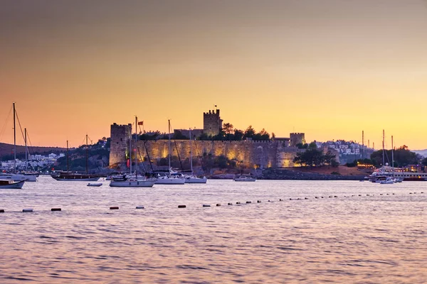 12 Temmuz 2022, Türkiye, Bodrum, şehir plajı. İnsanlar sahildeki masalarda oturup gün batımını seyrediyorlar. Gece manzarası