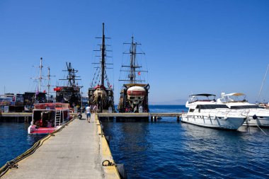 Boats and yachts on the pier. Tourists walk along the embankment of the resort town of Bodrum. Bodrum Turkey July 12, 2022. View of Marina