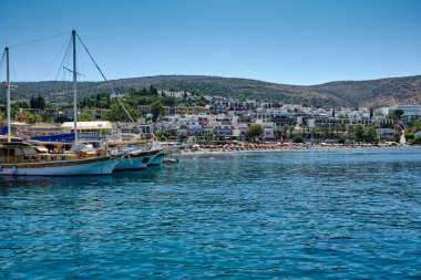 Boats and yachts on the pier. Tourists walk along the embankment of the resort town of Bodrum. Bodrum Turkey July 12, 2022. View of Marina