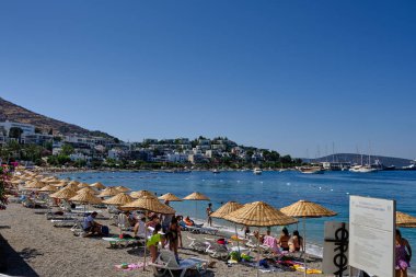 Boats and yachts on the pier. Tourists walk along the embankment of the resort town of Bodrum. Bodrum Turkey July 12, 2022. View of Marina