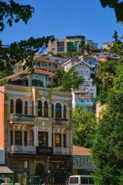 Istanbul, Turkey, July 18, 2022. Beautiful and colorful old buildings in the Arnavutkoy region on the embankment of Bosphorus. People walk the streets