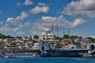 İstanbul, Türkiye - 19 Temmuz 2022, Pier Eminonia ve kentin Avrupa kesimi, Süleyman Camii, Galata Köprüsü ve Boğazı manzaralı. Şehrin tarihi merkezinde otelleri ve restoranları olan eski binalar. Paslı feribotlar