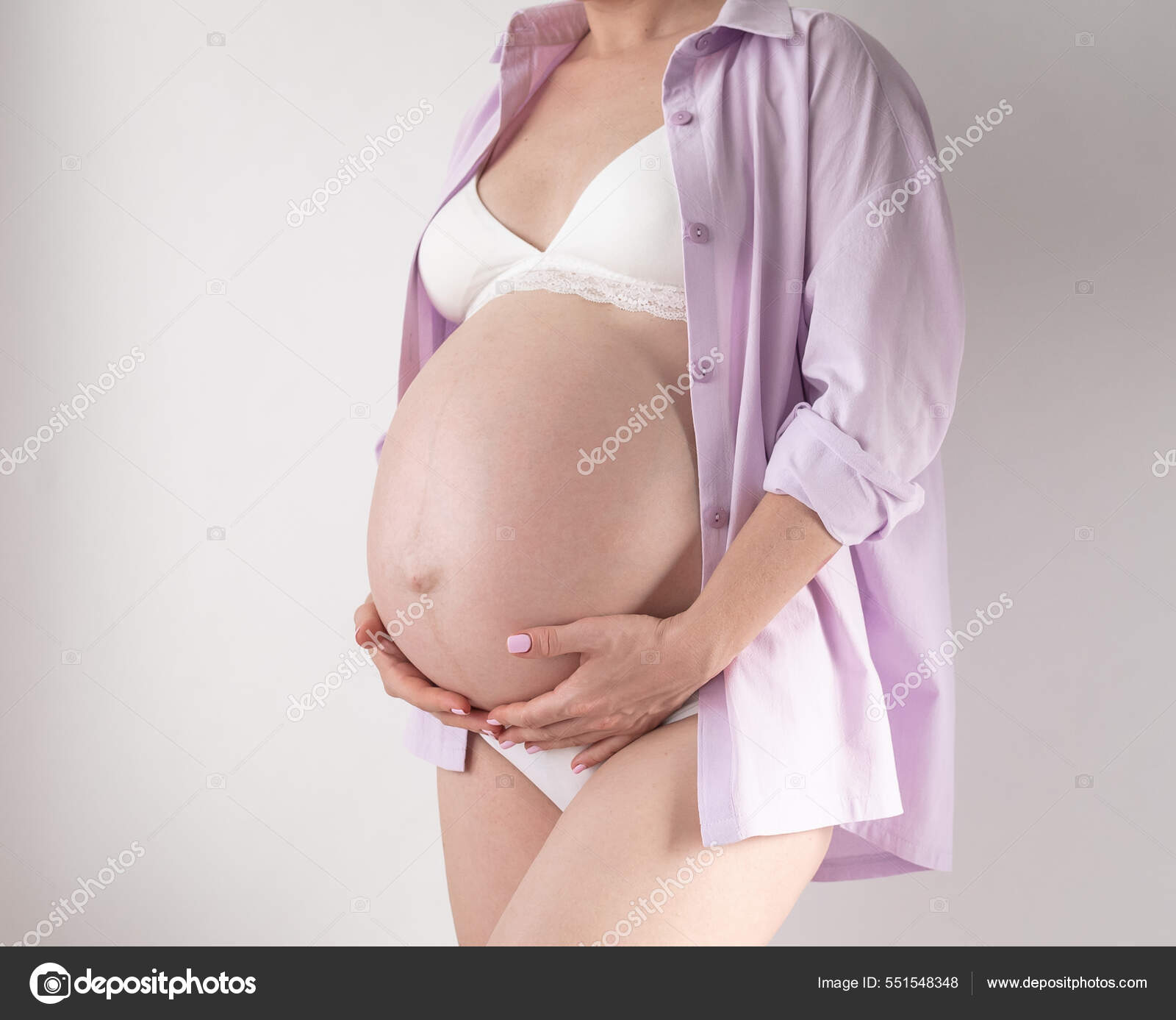 Una mujer embarazada en ropa interior y una camisa rosa sobre un fondo  blanco: fotografía de stock © conssuella #551548348