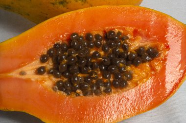 Beyaz arka planda izole edilmiş tohumlarla taze olgun Papaya 'nın yarısı. Seçici odak.