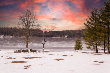 Sunset on the lake the day after it snows. clipart