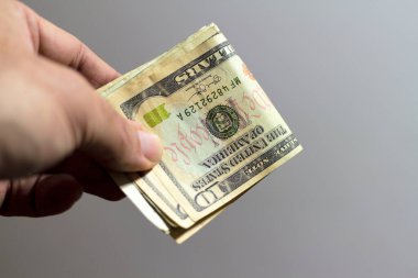 Male hand holding a dollars banknotes. Selective focus of a man with American money closeup.