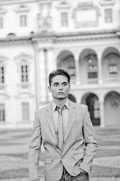 Attraktiver junger Mann zu Fuß, eleganten Palast hinter — Stockfoto