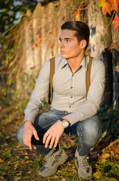 Stilig ung man på hösten (hösten) framför trä staket — Stockfoto
