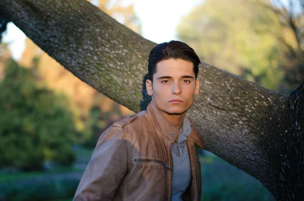 Modelo masculino jovem atraente no outono (outono) ao ar livre na natureza — Fotografia de Stock