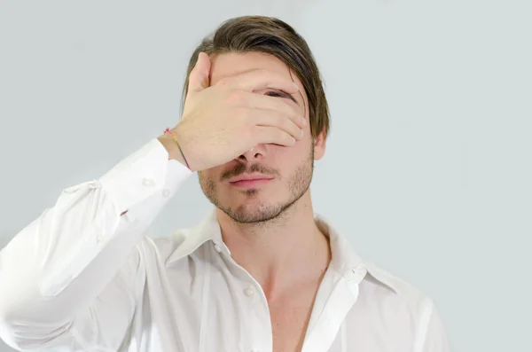 Jovem bonito cobrindo os olhos com a mão — Fotografia de Stock