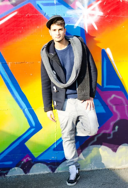 Full body shot of young man in front of graffiti — Stock Photo, Image