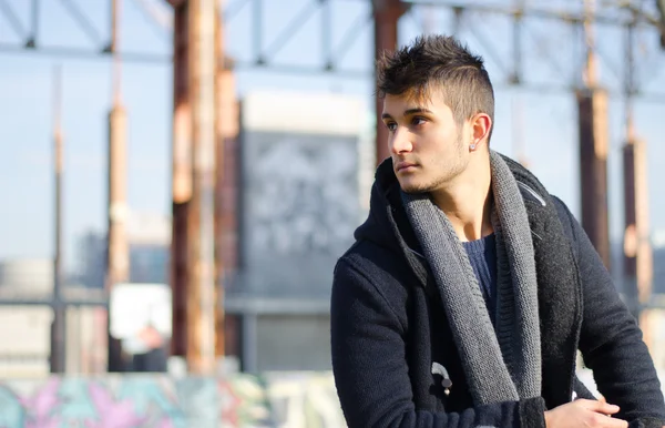 Handsome young man in urban or industrial setting, large copyspace — Stock Photo, Image