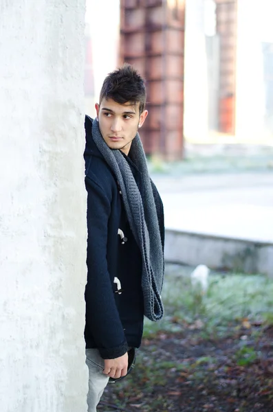 Attractive young man behind white wall — Stock Photo, Image