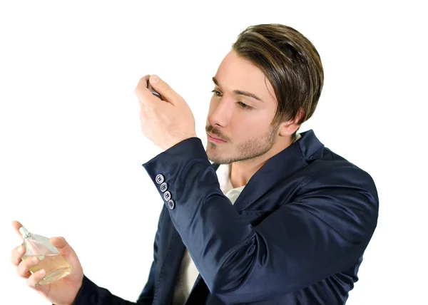 Handsome young man smelling perfume or cologne — Stock Photo, Image