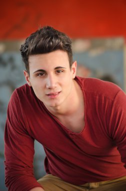 yakışıklı genç adam, kırmızı bir gömlek ile oturuyor