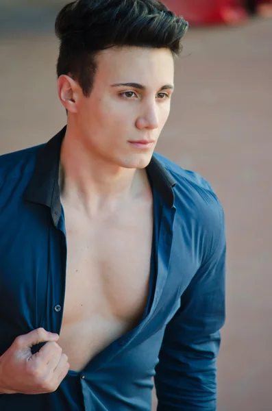 Handsome young man standing with open shirt showing torso — Stock Photo, Image