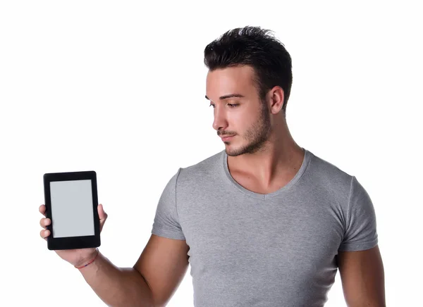 Attractive young man holding and looking at ebook reader Royalty Free Stock Photos