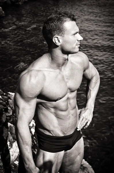 Foto preto e branco da jovem atraente muscular à beira-mar — Fotografia de Stock