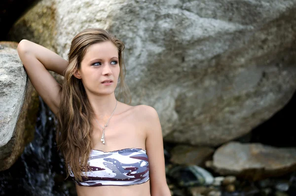 Söt flicka i bikini mot rock — Stockfoto