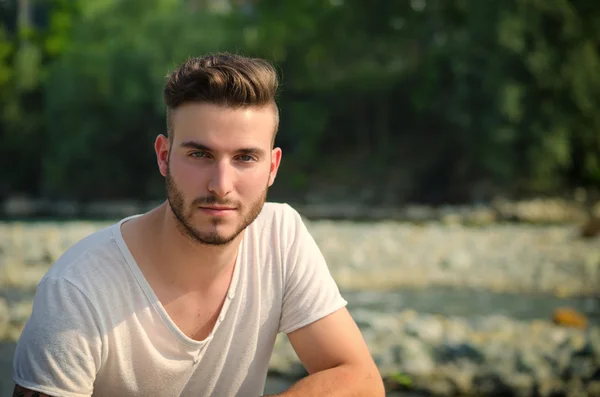 Porträt von hübscher junger Mann im weißen T-shirt im freien — Stockfoto