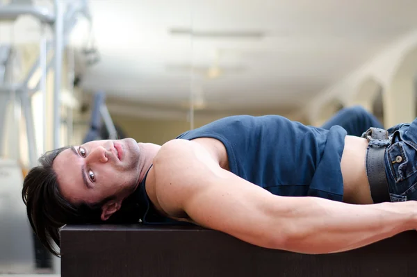 Handsome young man laying on his back, looking to a side — Stock Photo, Image