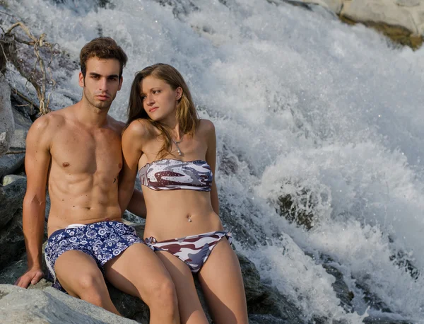 Romantic couple next to river waterfall — Stock Photo, Image