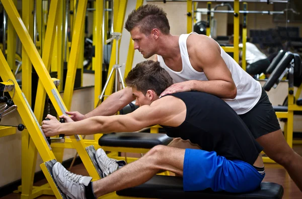 Persoonlijke trainer helpen client in gym — Stockfoto