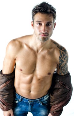 Çıplak gövdeye deri ceket giyen yakışıklı genç adam.