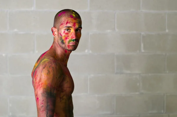 Attractive young man with skin painted with Holi colors — kuvapankkivalokuva