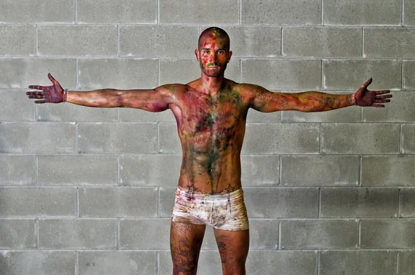 Séduisante jeune homme avec peau peintes avec des couleurs holi — Photo