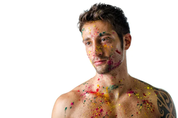 Atletische jonge man shirtless, huid geschilderd met holi kleuren — Stockfoto