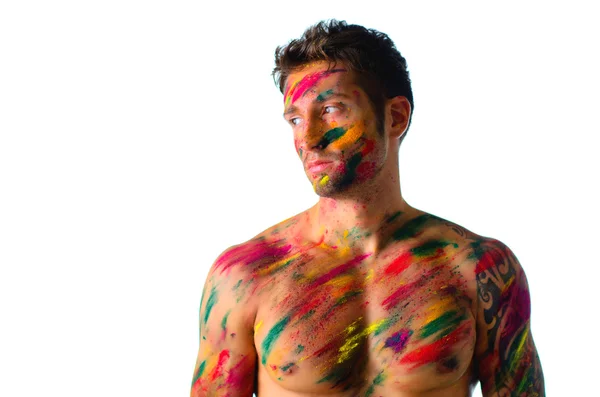 Atletische jonge man shirtless, huid geschilderd met holi kleuren — Stockfoto