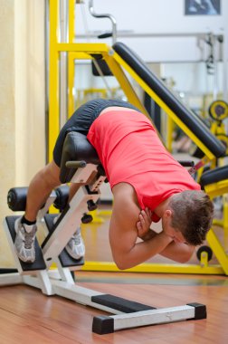 Spor aletleri üzerinde çalışan yakışıklı genç adam.