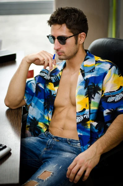 Schöner junger Mann mit offenen Hemd an seinem Büro-Schreibtisch — Stockfoto