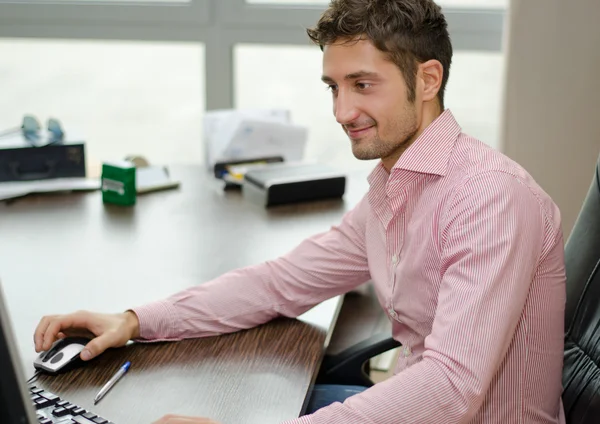 Gut aussehend, fröhlich Büroangestellter lächelnd bei der Verwendung von computer — Stockfoto