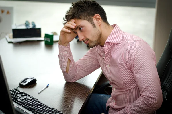 Preocupado, preocupado jovem trabalhador masculino olhando para computador — Fotografia de Stock