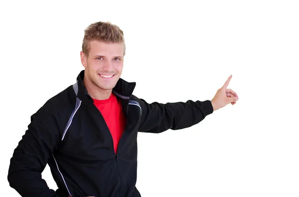 Smiling, young personal trainer pointing finger at blank space — Foto Stock