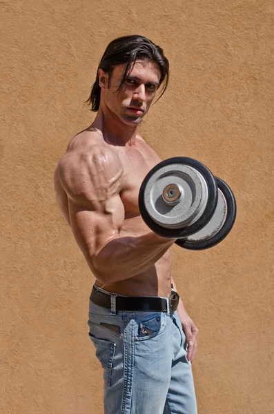 Muscular young bodybuilder shirtless with dumbbell — Stock Photo, Image