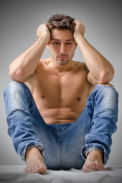 Sad or depressed young man shirtless, sitting on the floor — Stock Photo, Image