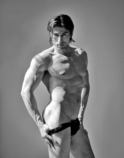 Przystojny mięśni mężczyzna przystojny noszenie bielizny na szarym tle — Zdjęcie stockowe