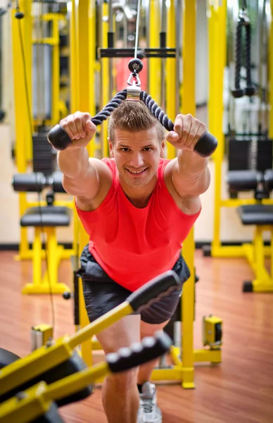 Young man training on gym equipment — Stock Photo, Image