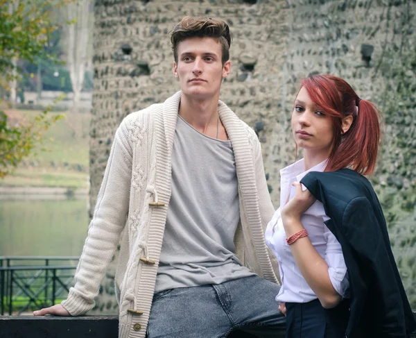 Young elegant couple outdoors near old stone wall — Stock Photo, Image