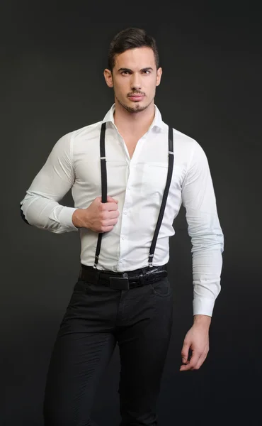 Jovem elegante com camisa branca e suspensórios, expressão séria — Fotografia de Stock