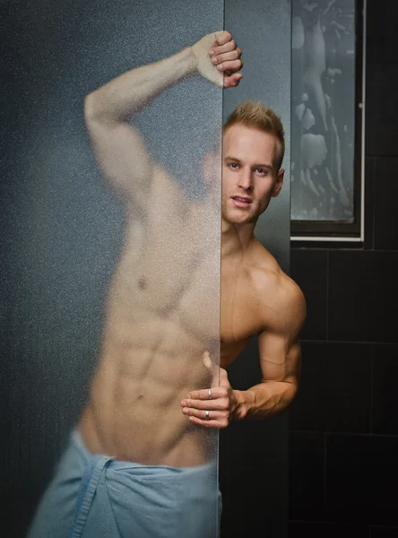 Jovem bonito sem camisa atrás de vidro do chuveiro — Fotografia de Stock