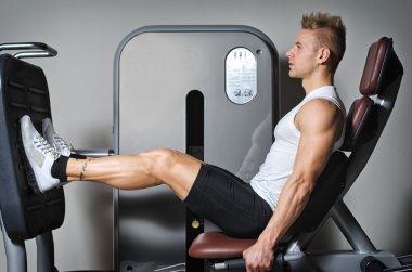 Çekici ve formda bir genç adam spor yapıyor.