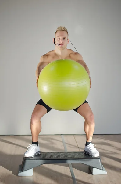 Young aerobics male coach on step with big ball teaching class — Stock Photo, Image