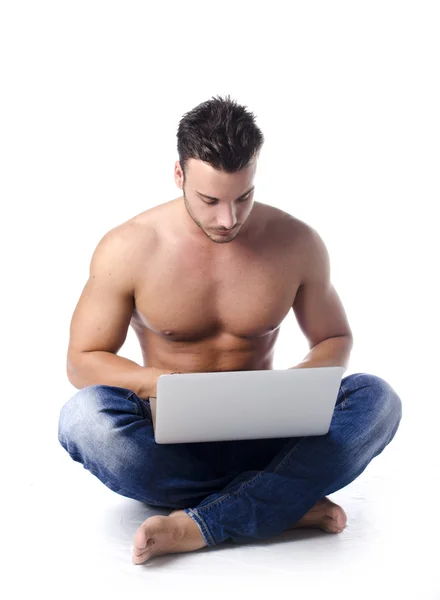 Muscular, shirtless young man on the floor using laptop computer — Stock Photo, Image