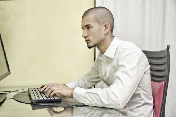 Jonge man aan het werk vanuit huis op computer — Stockfoto