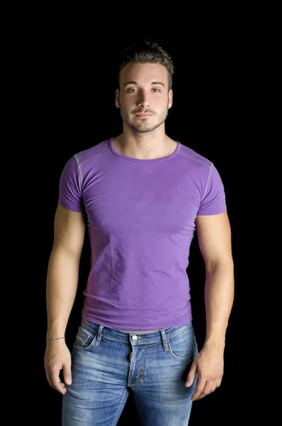 Handsome friendly young man standing in t-shirt and jeans — Stock Photo, Image